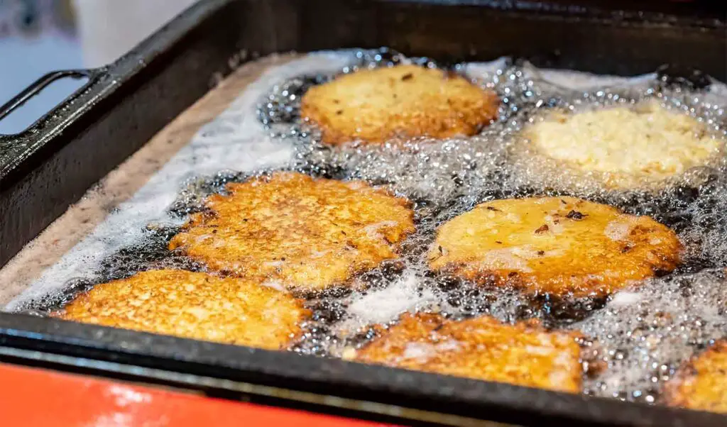 Polish placki ziemniaczane being fried in oil.