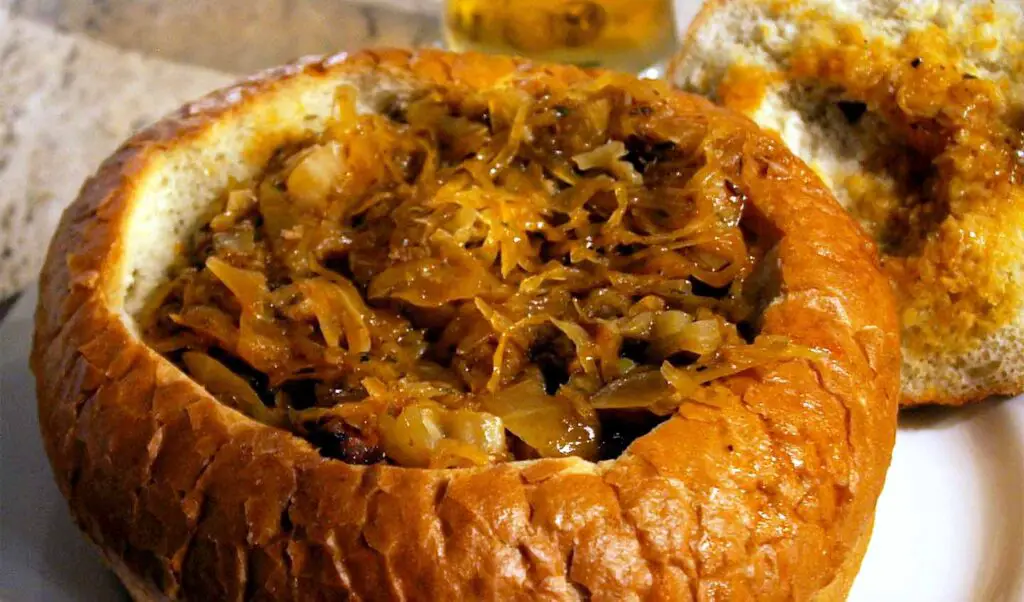 A large portion of bigos in a bread bowl.